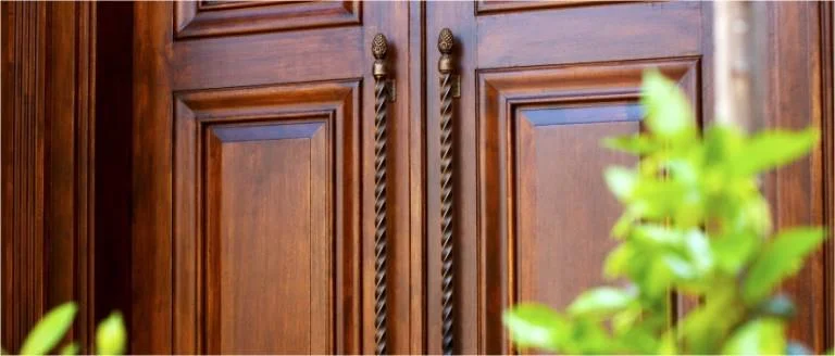 Detail of a solid timber panel door with wrought hardware