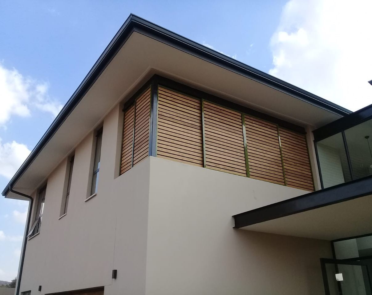Exterior timber louvre shutters fitted over upper-storey windows