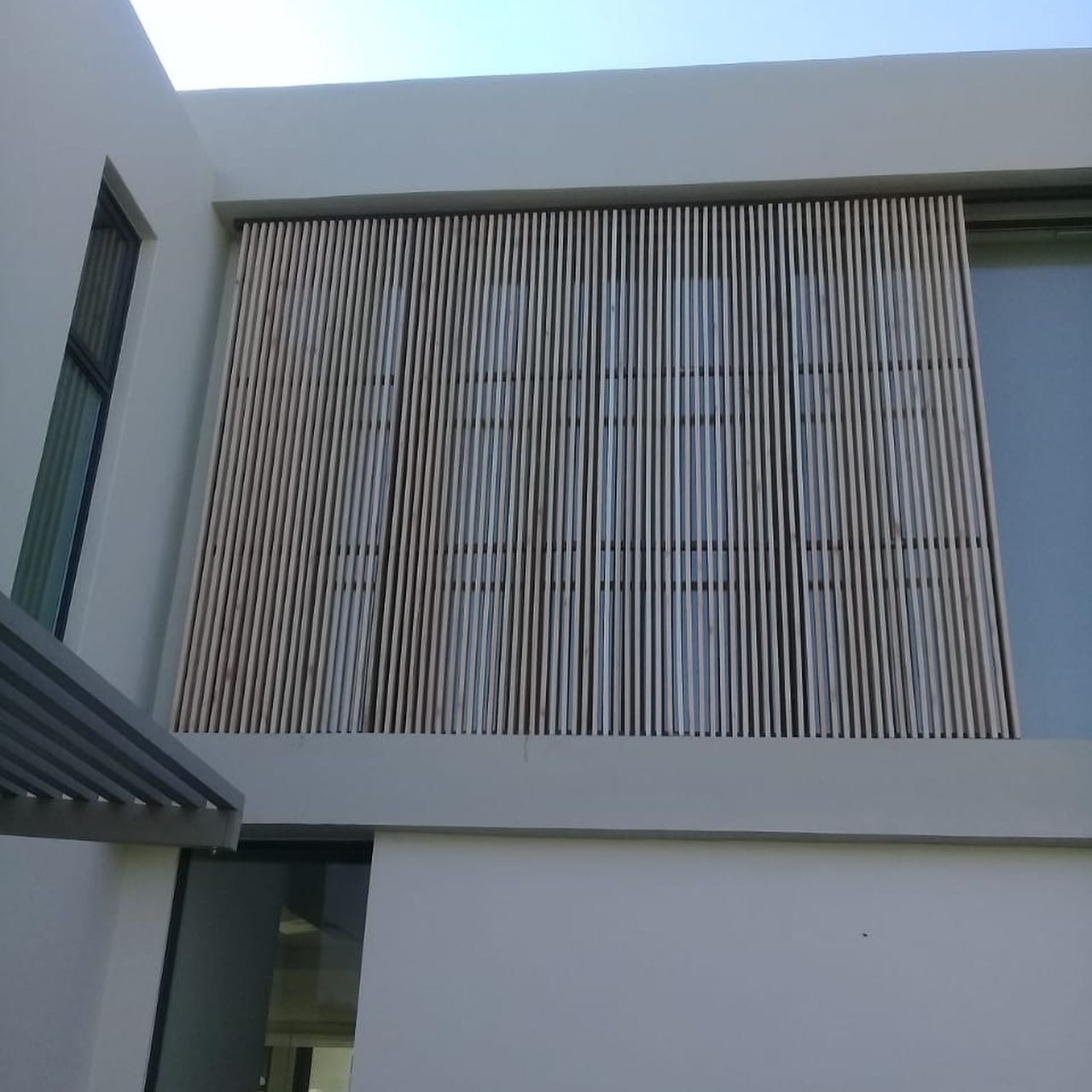 Vertical timber slat screen fitted over an upper-storey window
