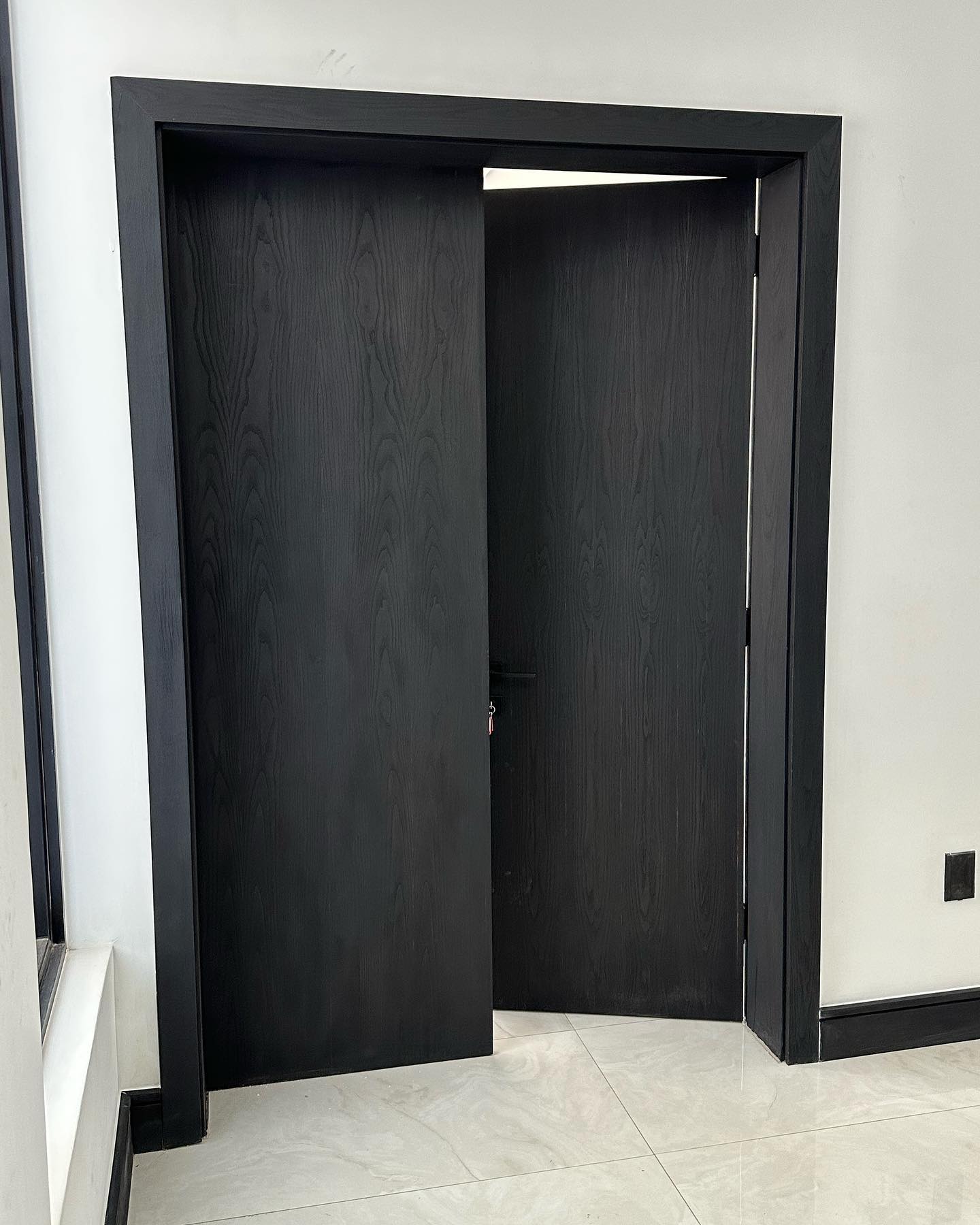 Dark ash veneer double door, one leaf open
