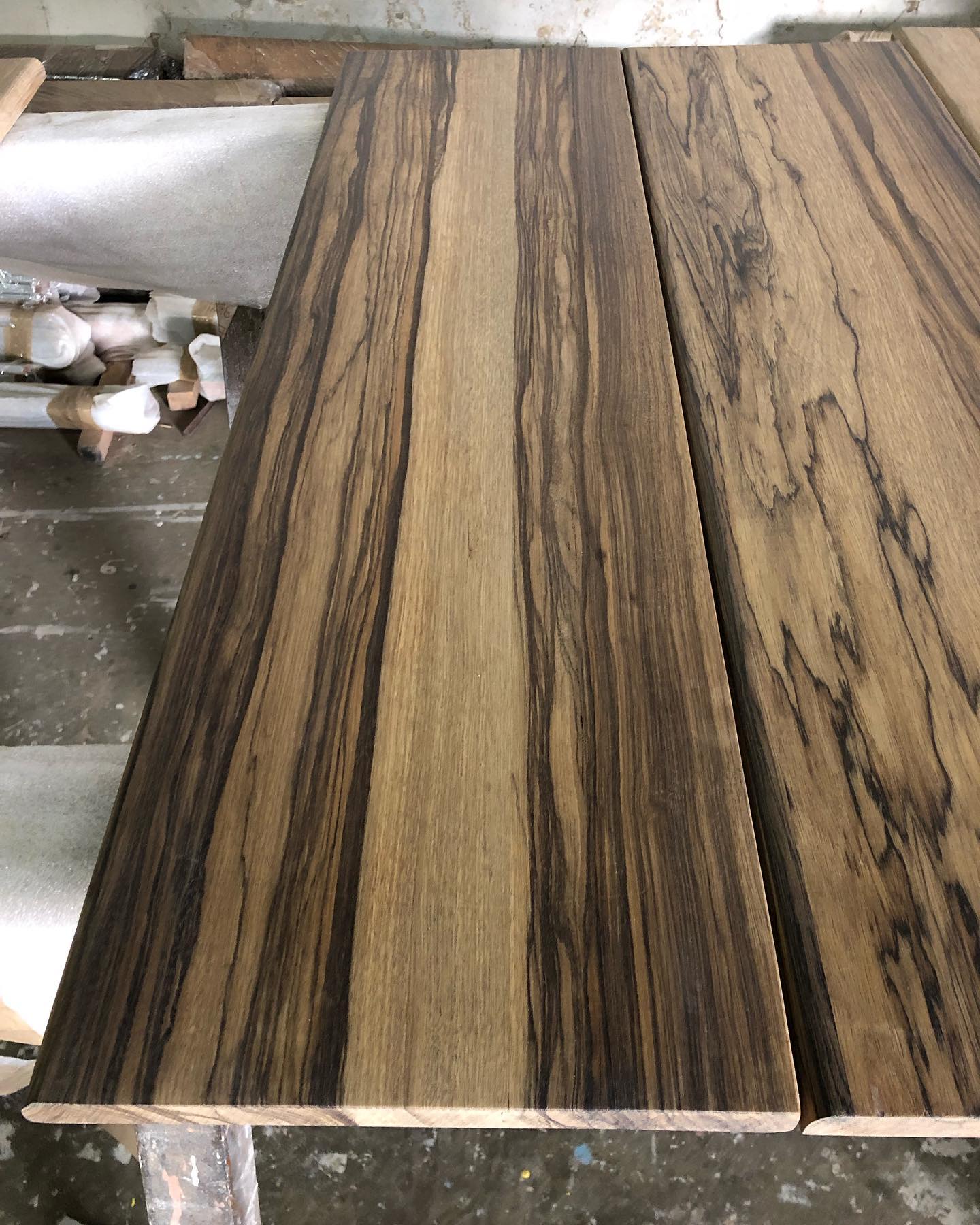Raw timber planks in the workshop, showing natural grain and colour variation