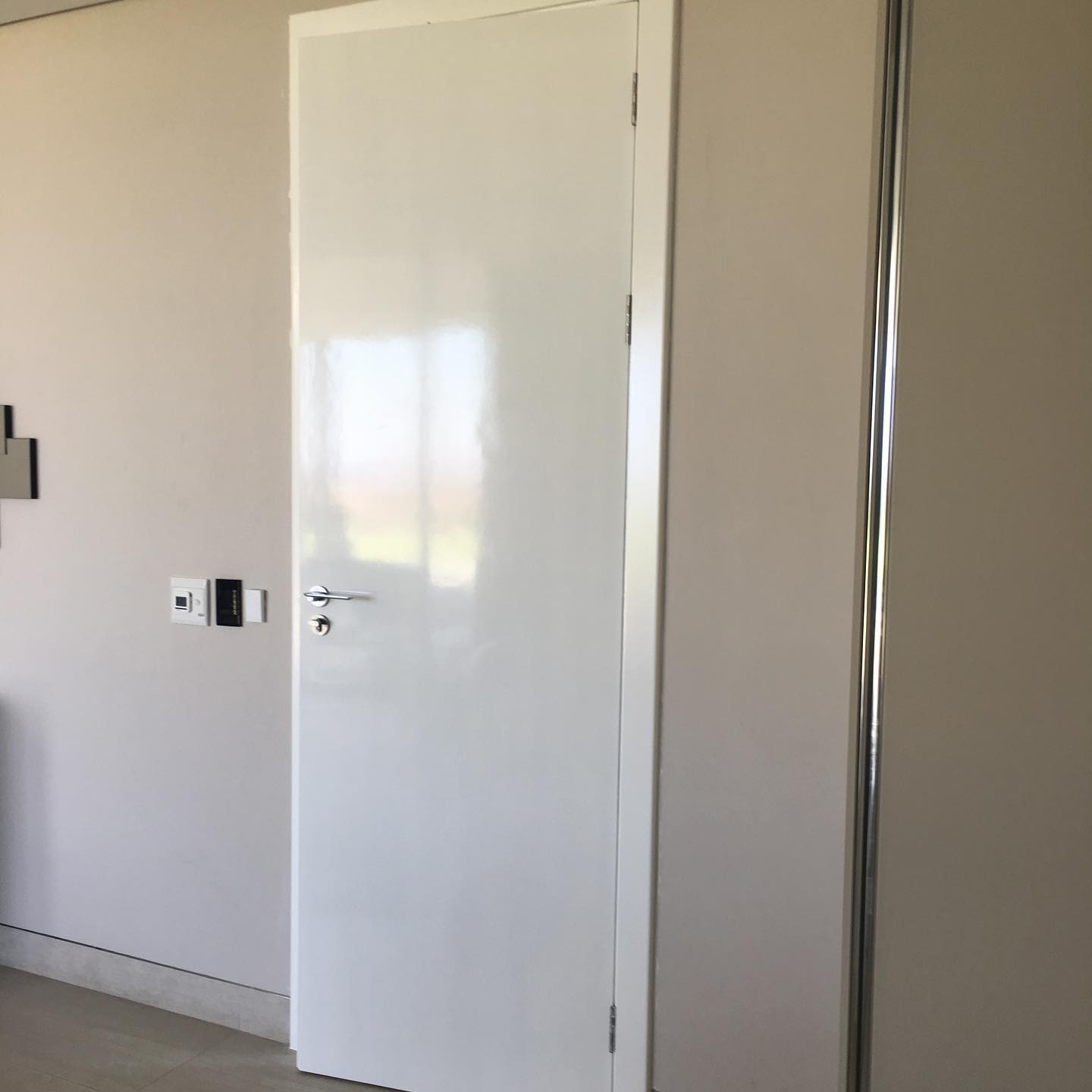 Simple white flush interior door with chrome handle