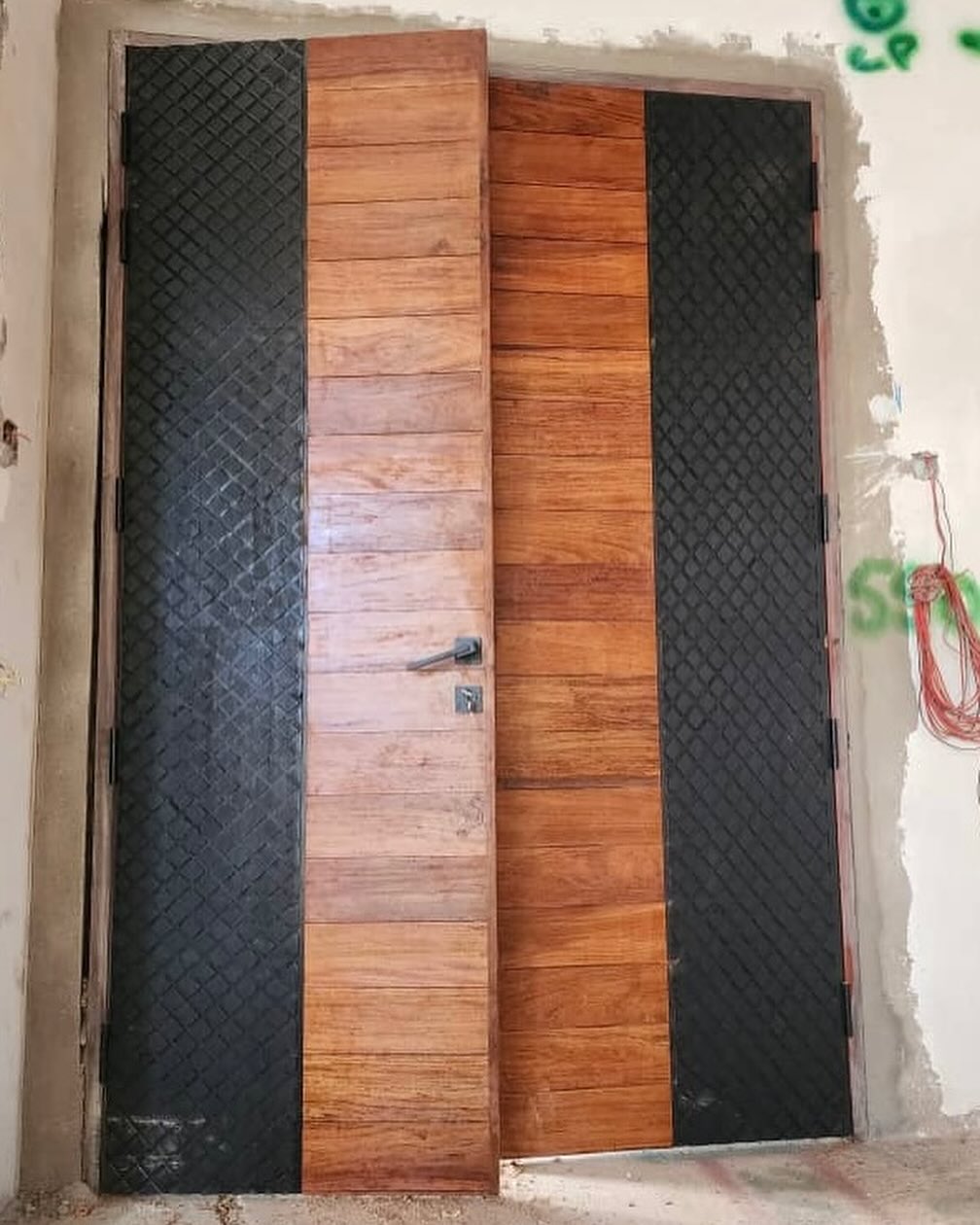 Textured black and timber double door under construction