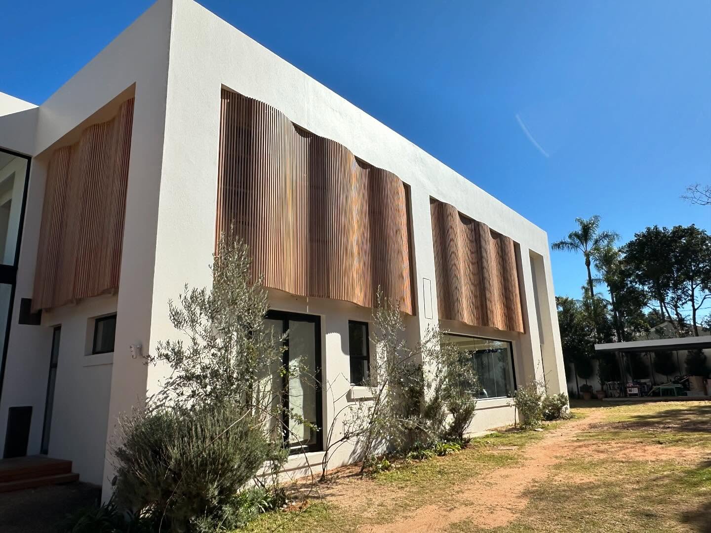 Curved-profile timber screen facade on a two-storey house