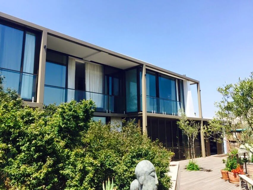 Modern residence with full-height timber-framed glazing and louvred shutters