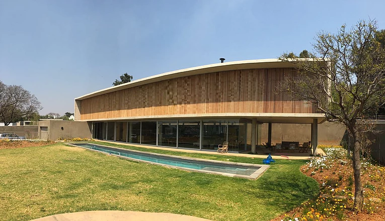 Modern residence with a curved vertical timber screen facade